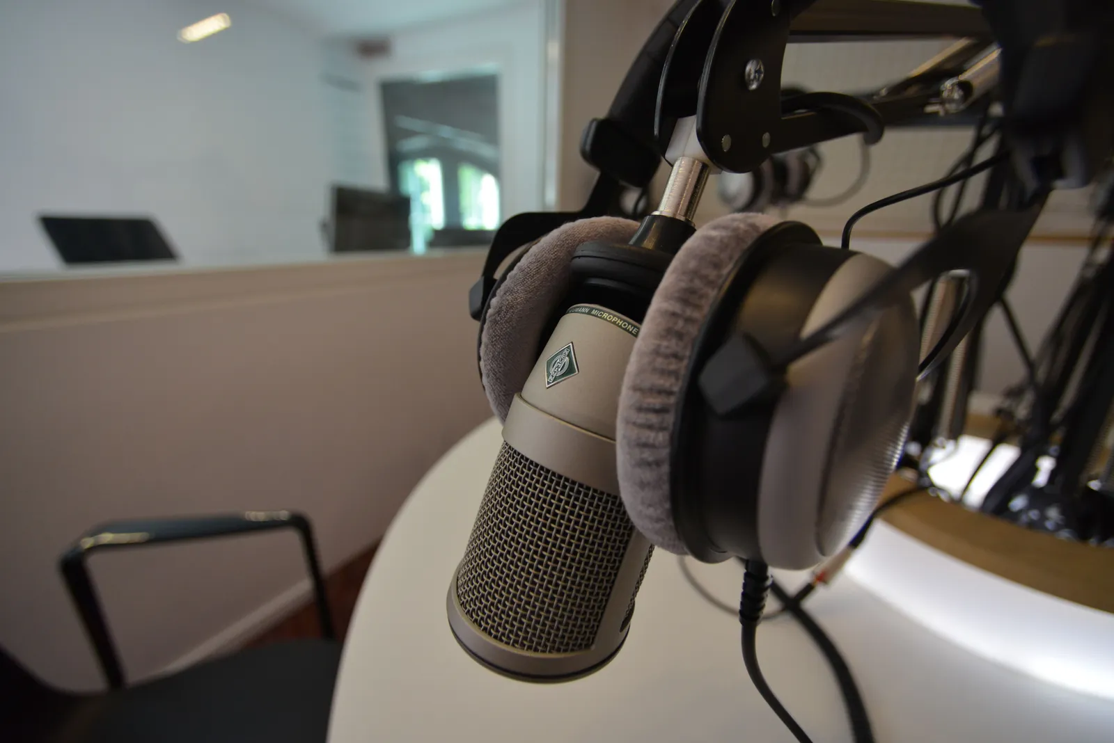 Close-up of a studio microphone with headphones in a recording setting, emphasizing audio quality