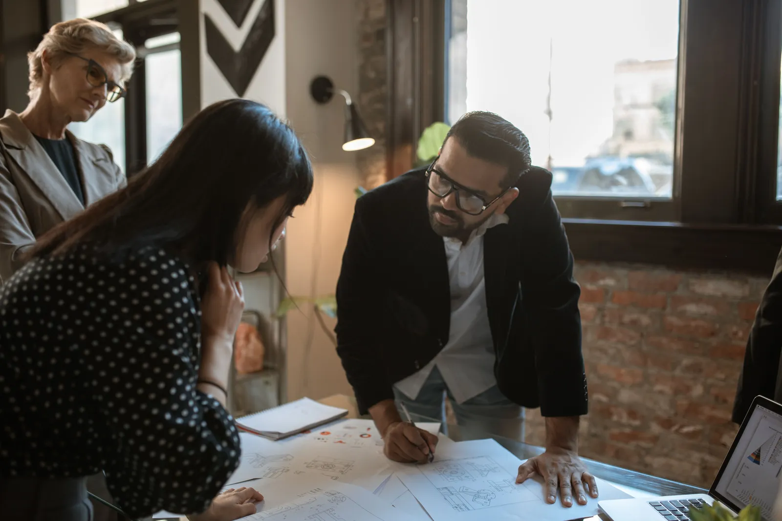 Team members engaged in a creative office brainstorming session around a desk