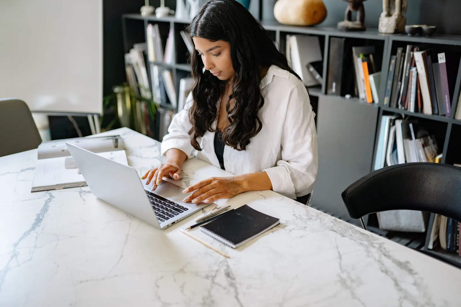 Confident businesswoman working on her laptop in a modern office setting. Perfect for business themes