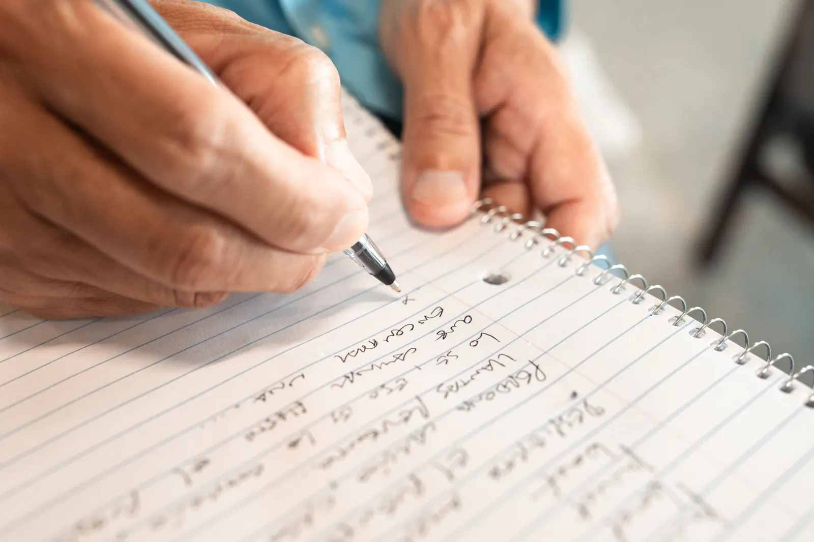 Detailed image of hands writing in a notebook, emphasizing creativity and organization