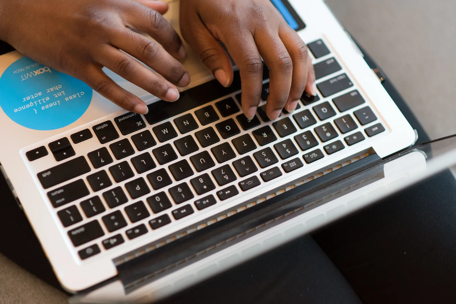 Close-up of hands typing on a laptop, showcasing modern technology and connectivity