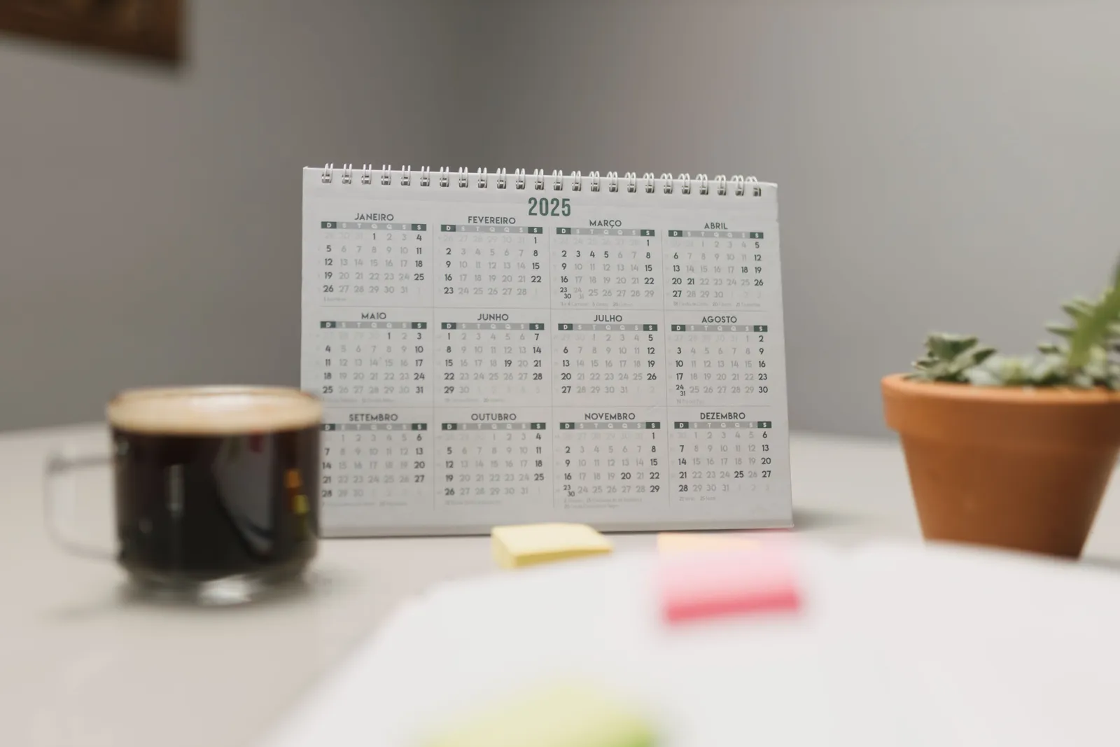 A 2025 desk calendar with coffee and succulent, ideal for planning and office decor
