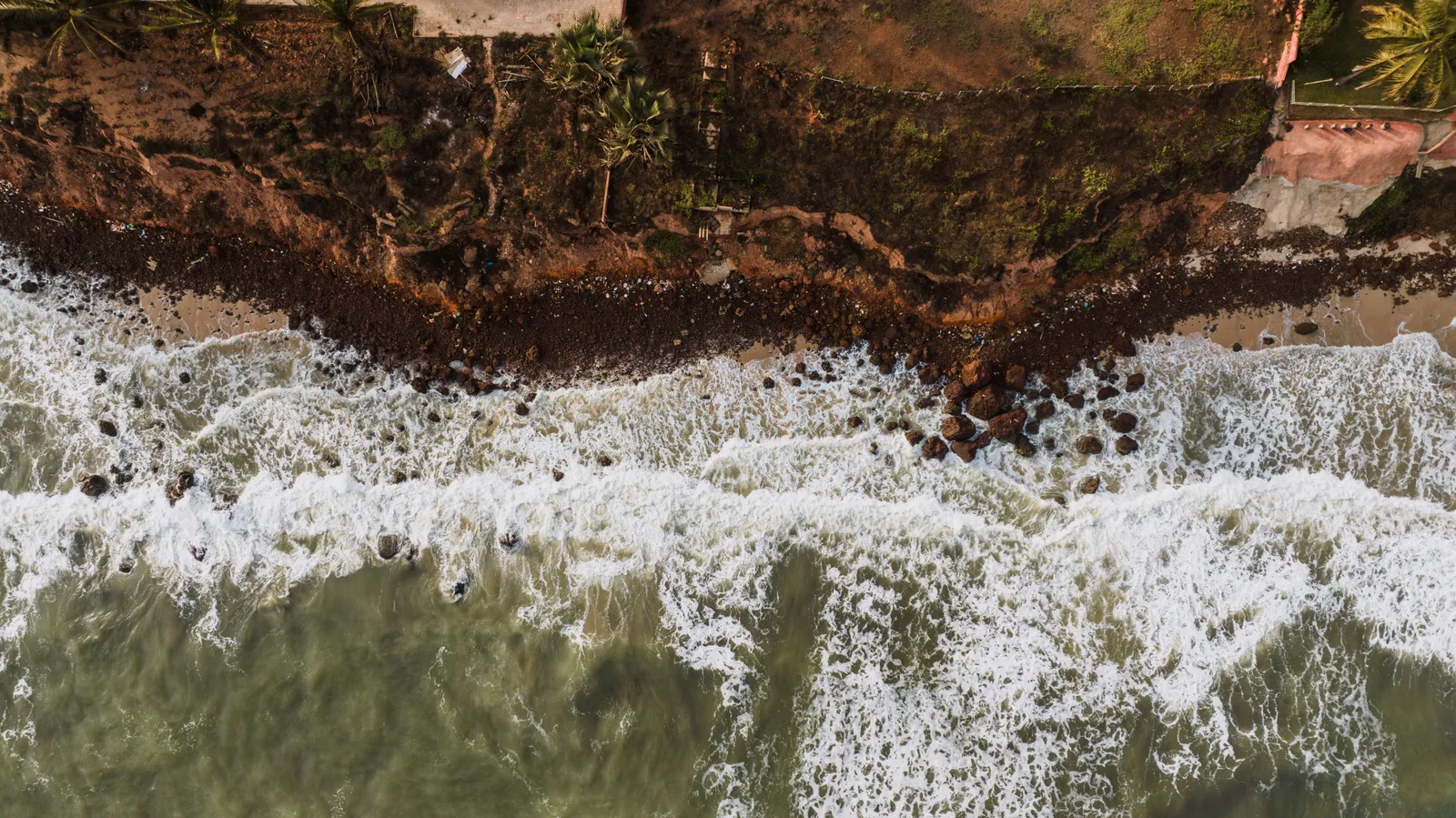 Drone shot capturing a dramatic view of ocean waves hitting a rocky coastline