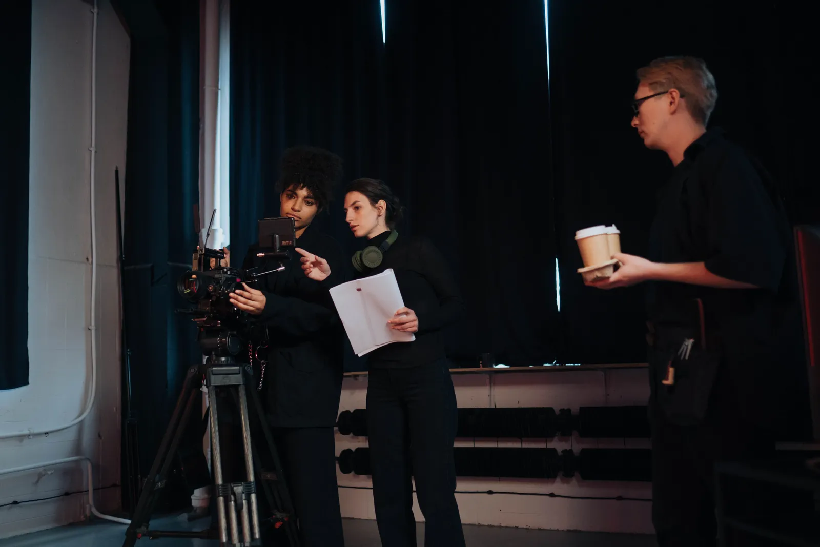 Film crew members collaborating on set, focusing on camera operations and planning