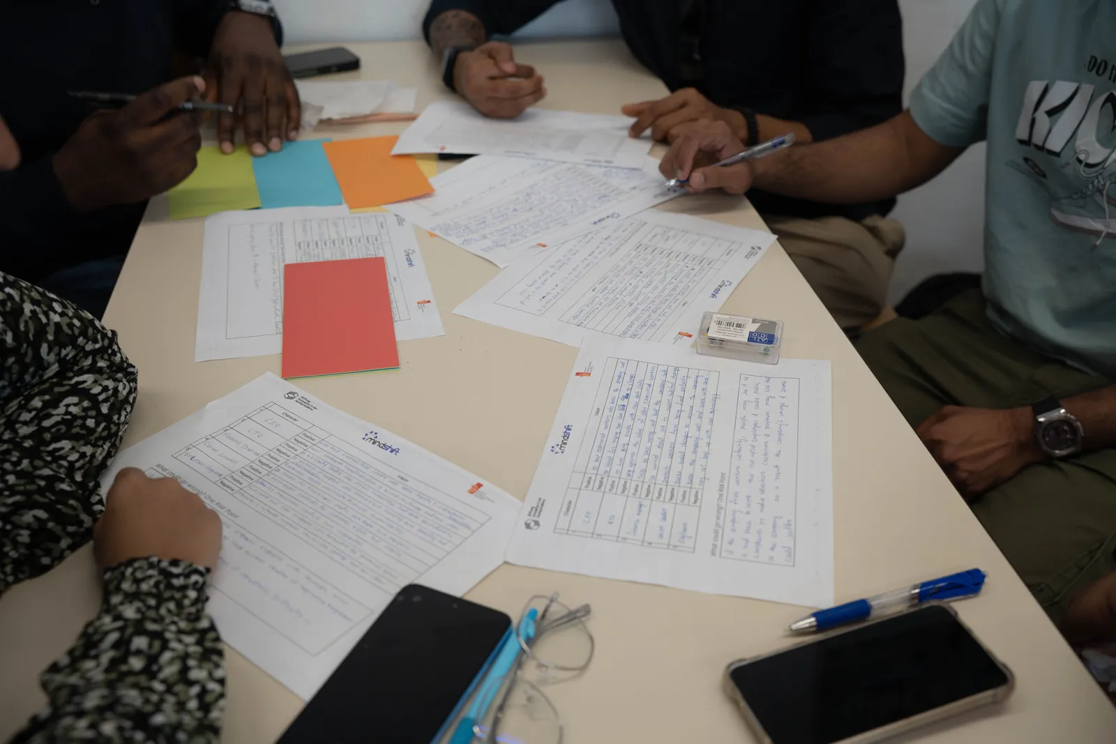 A diverse team working together, reviewing documents and making notes during a collaborative meeting