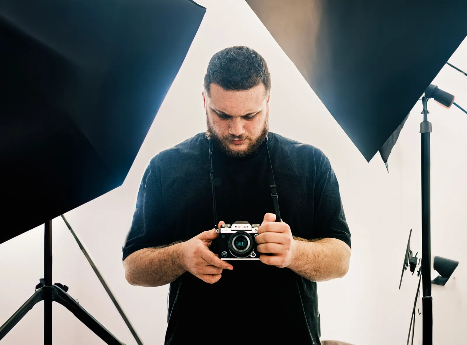 Professional photographer examining camera settings in a well-lit studio