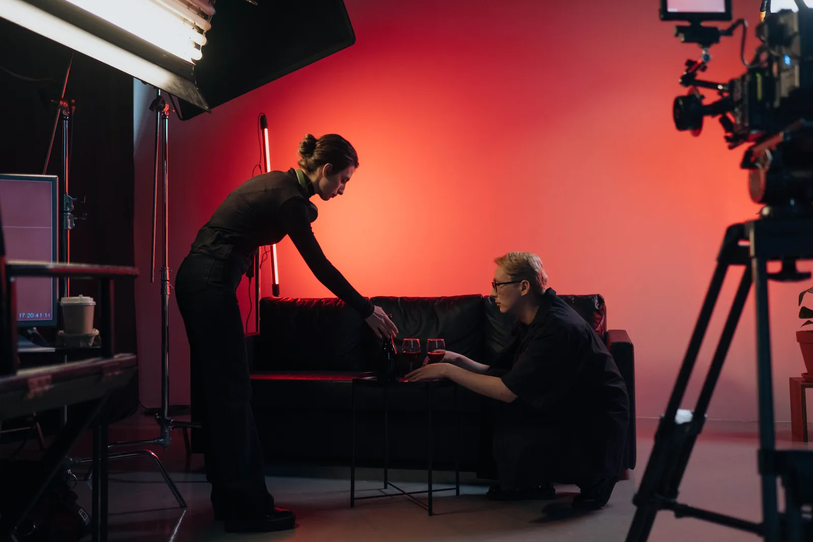Behind-the-scenes view of a film crew in action, setting up a studio scene with lighting and equipment
