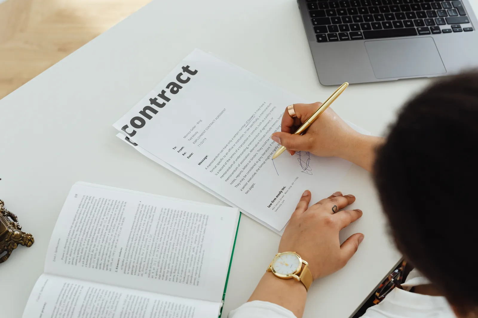 Professional signing a business contract at a modern desk setup for office work