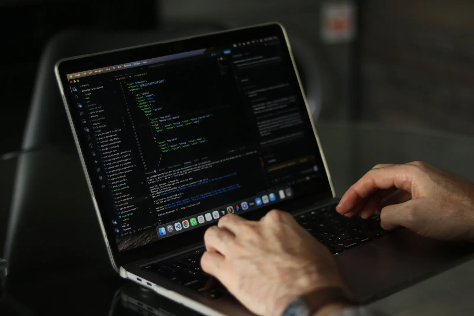 Close-up of hands coding on a laptop, focusing on programming productivity