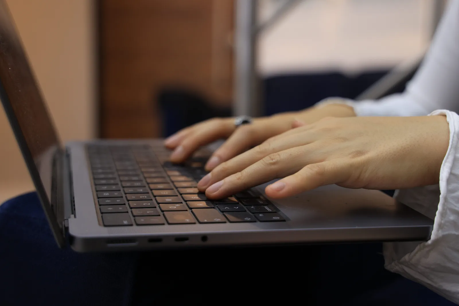 Hands typing on a laptop keyboard in an indoor setting. Perfect for business and technology themes