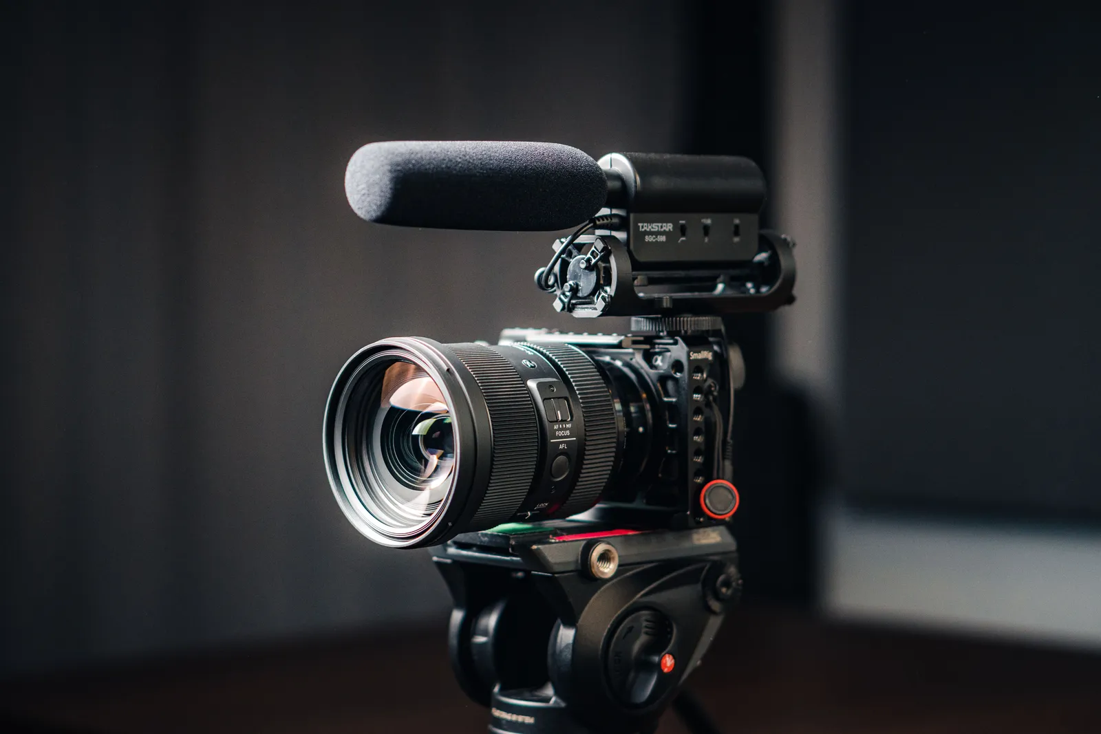 Close-up of a professional video camera with a mounted microphone on a tripod
