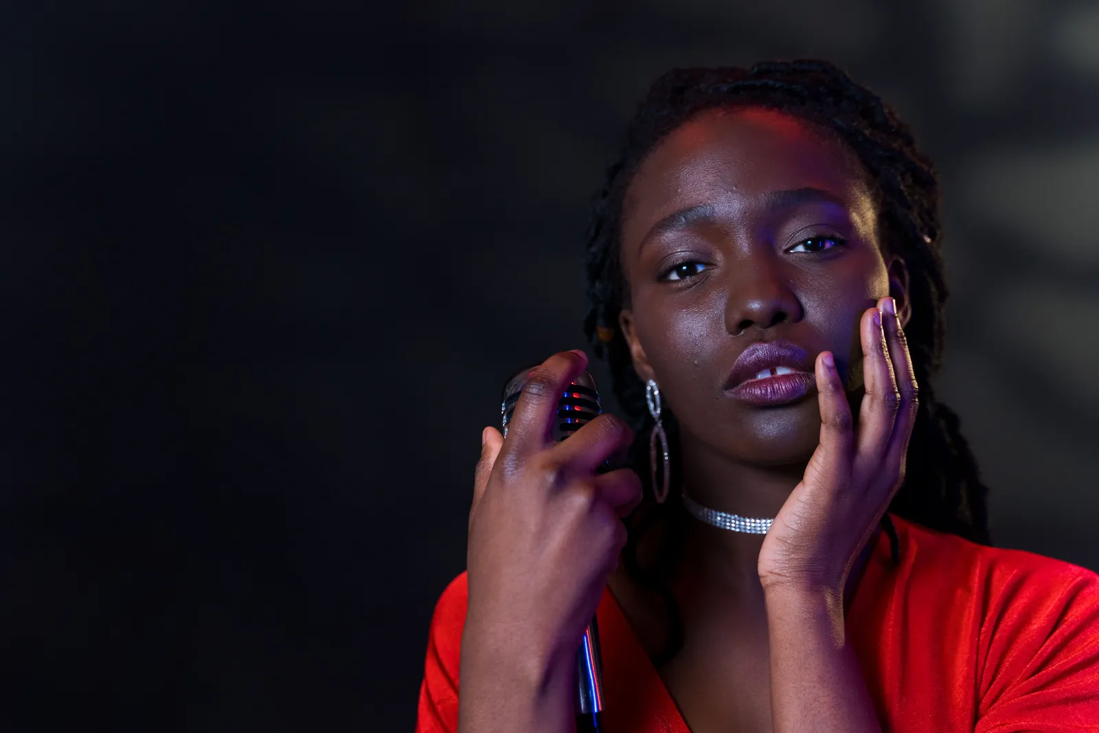 Close-up of an woman in a red dress holding a microphone, creating an emotional and artistic portrait
