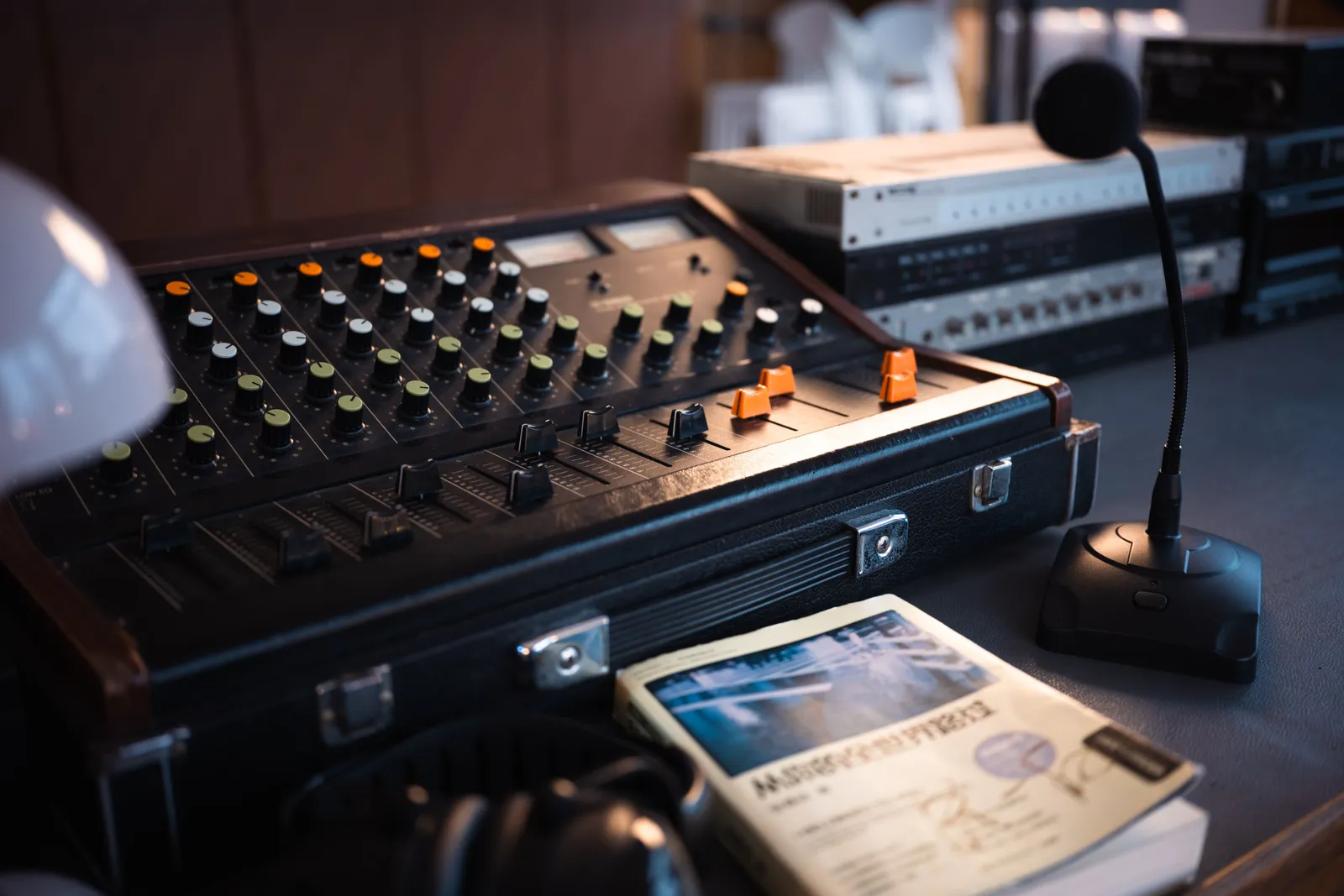 Close-up of a vintage audio mixer with a microphone and recording equipment on a desk