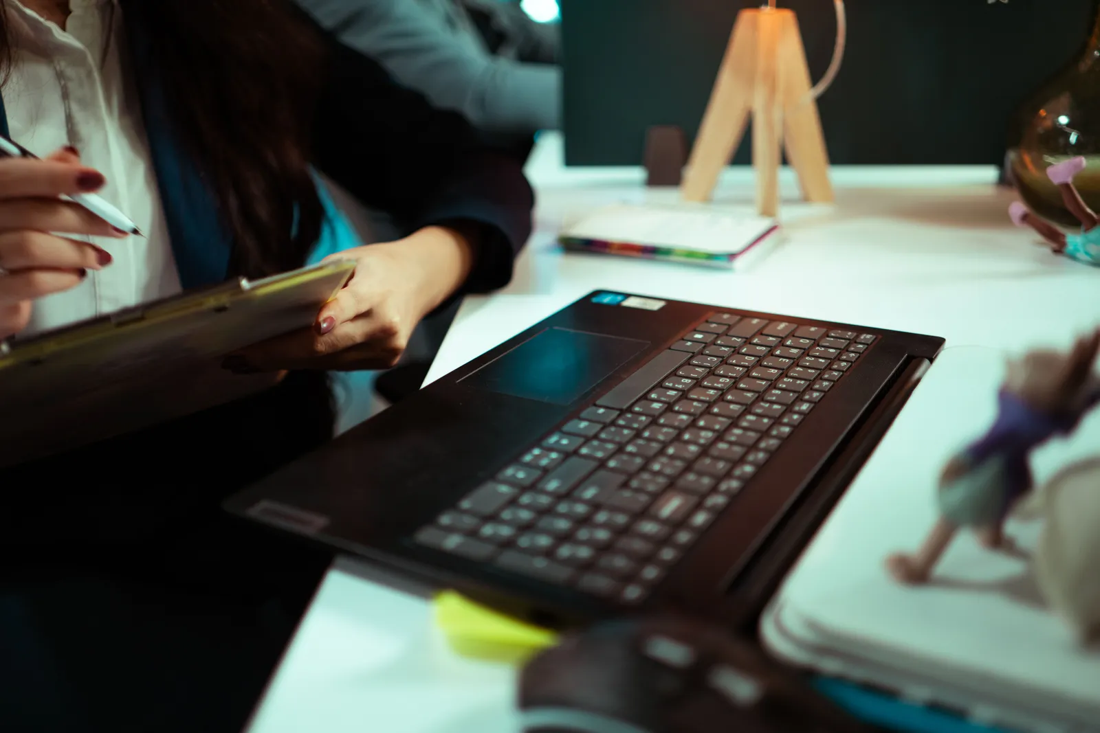 Businesswoman taking notes while working on a laptop in an office