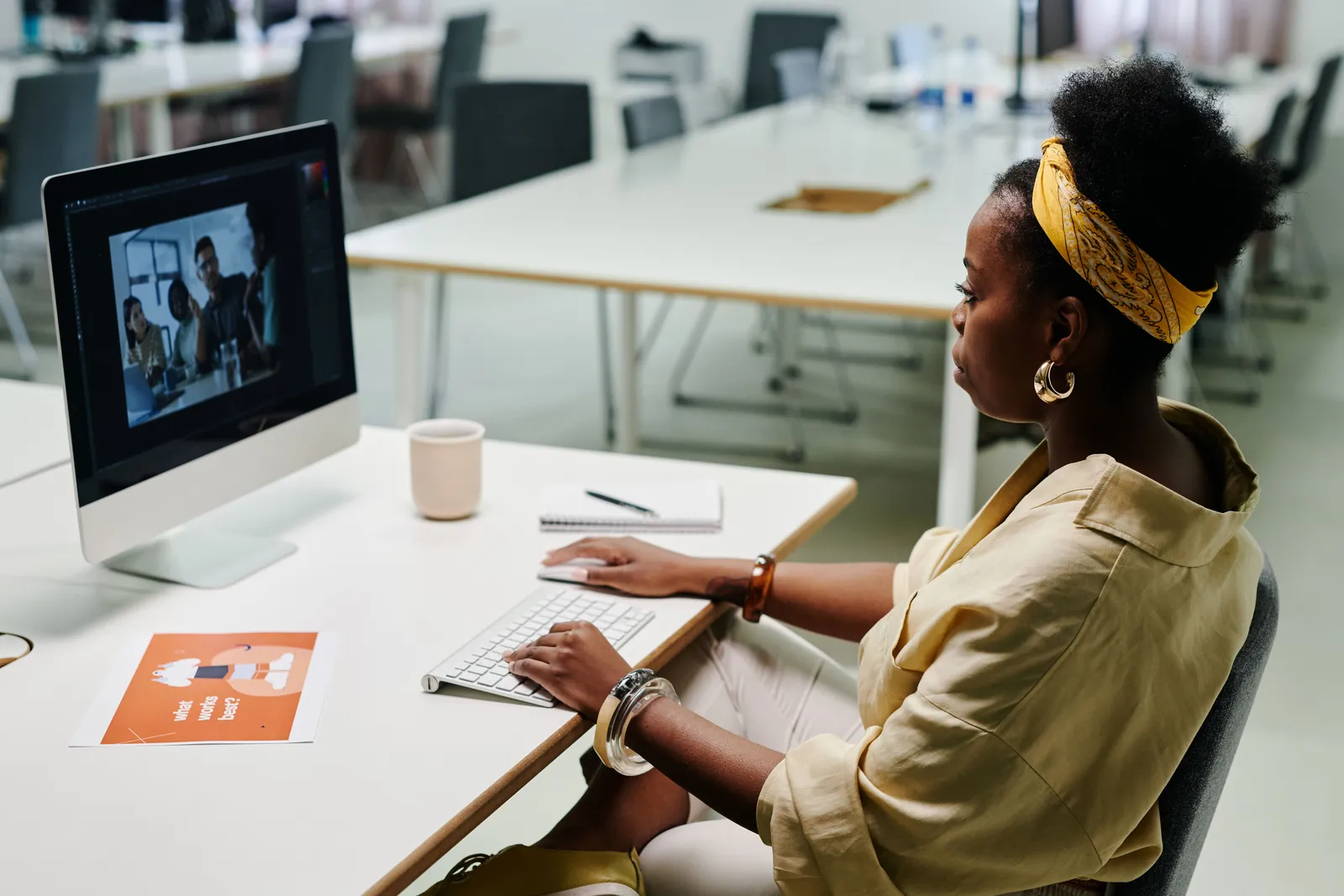 Young woman using computer for video editing in a modern office setting