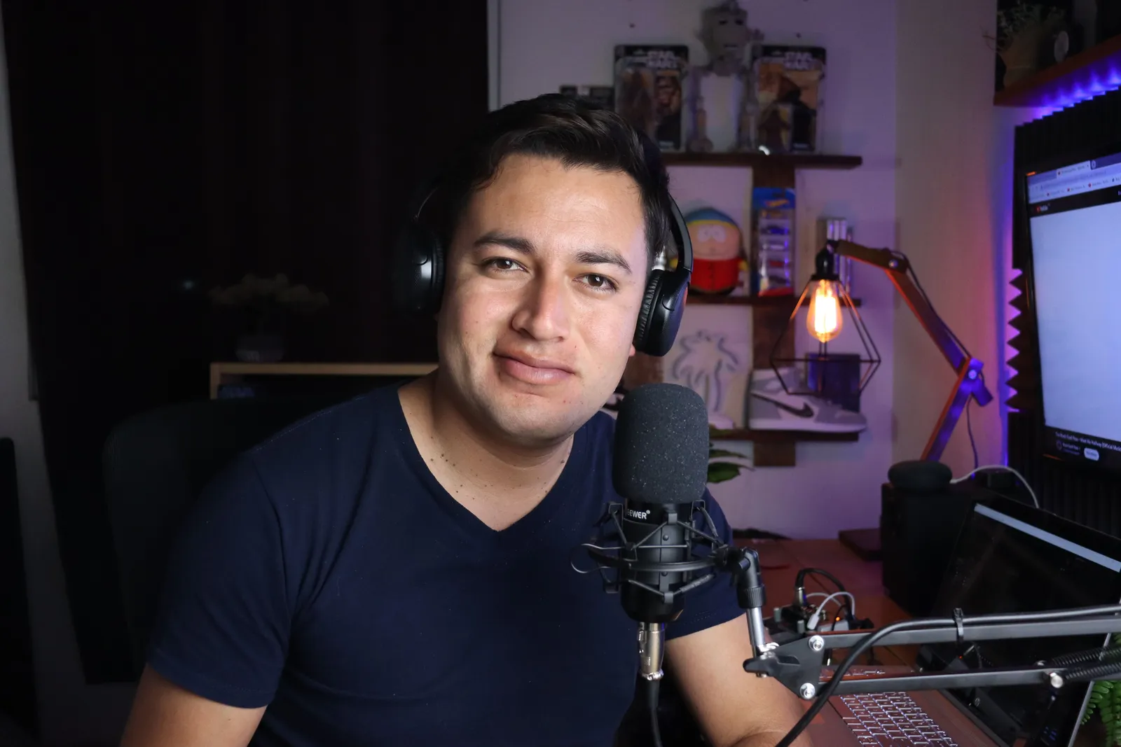Portrait of a man in a podcast studio with headphones and microphone