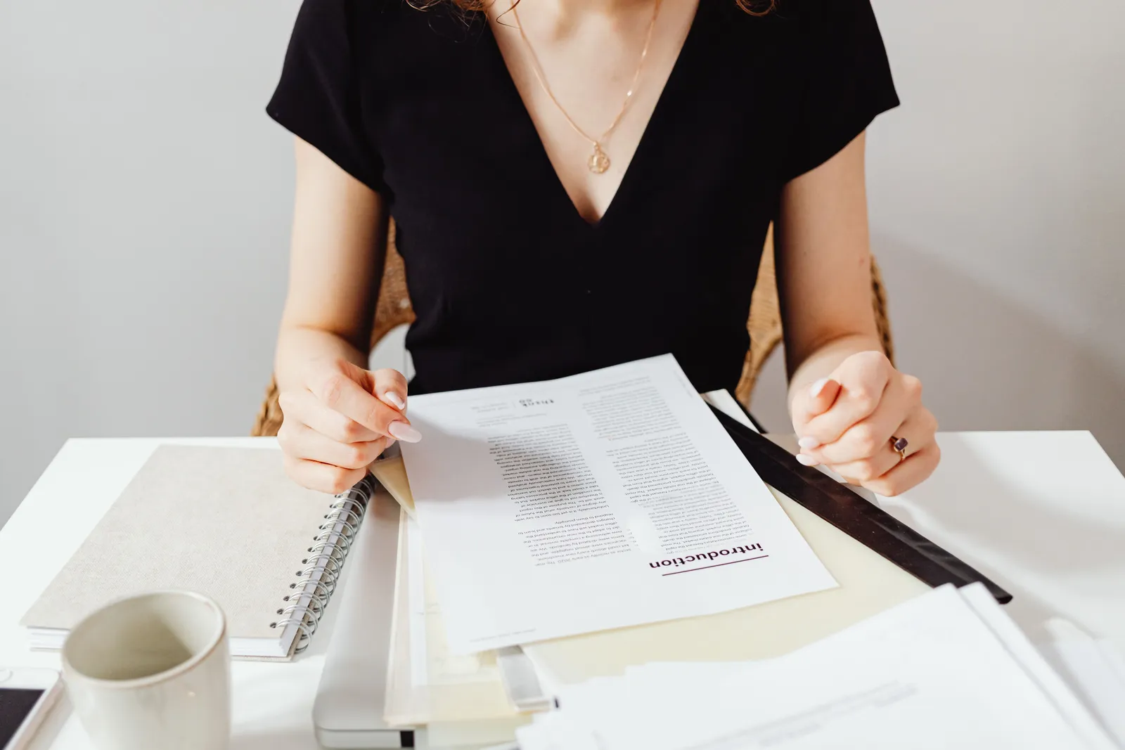 Woman sitting at a desk reviewing documents, featuring a casual work environment