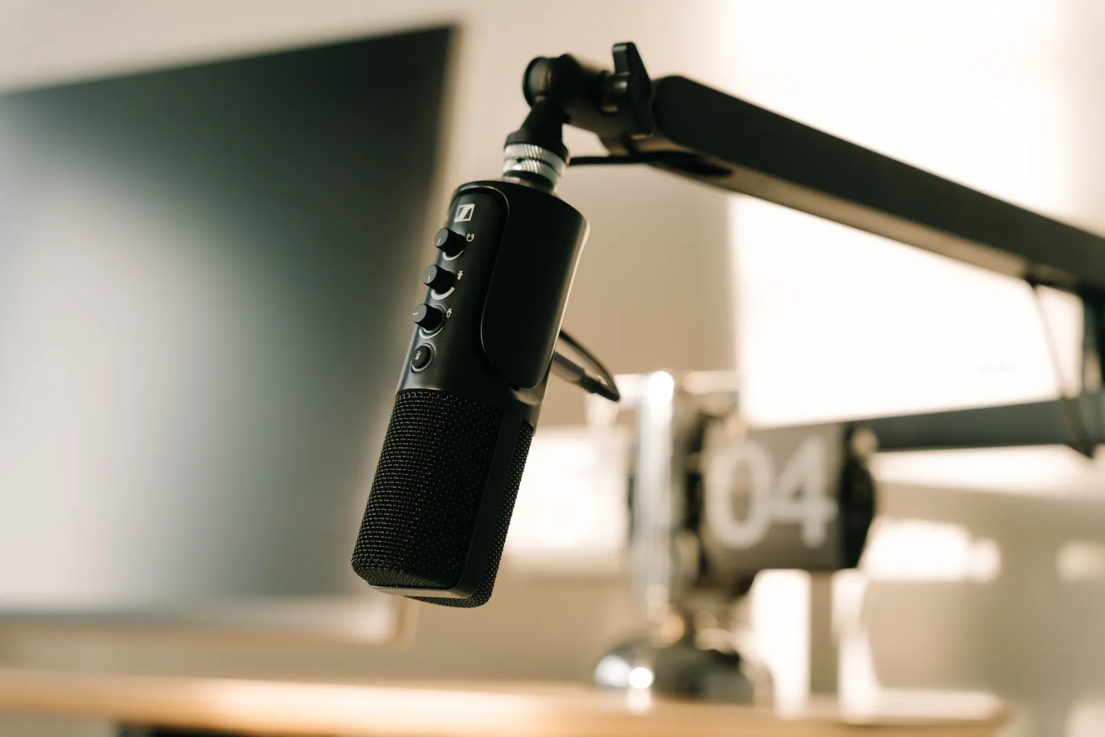 A studio microphone on a boom arm in soft, warm lighting, perfect for podcasts or voiceovers