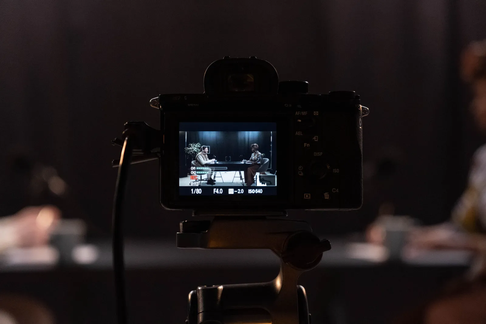 Close-up of a camera recording a podcast interview in a studio setting