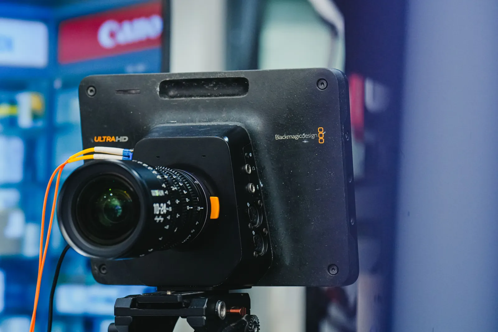Close-up of a professional video camera setup with lens on a tripod, ideal for filming