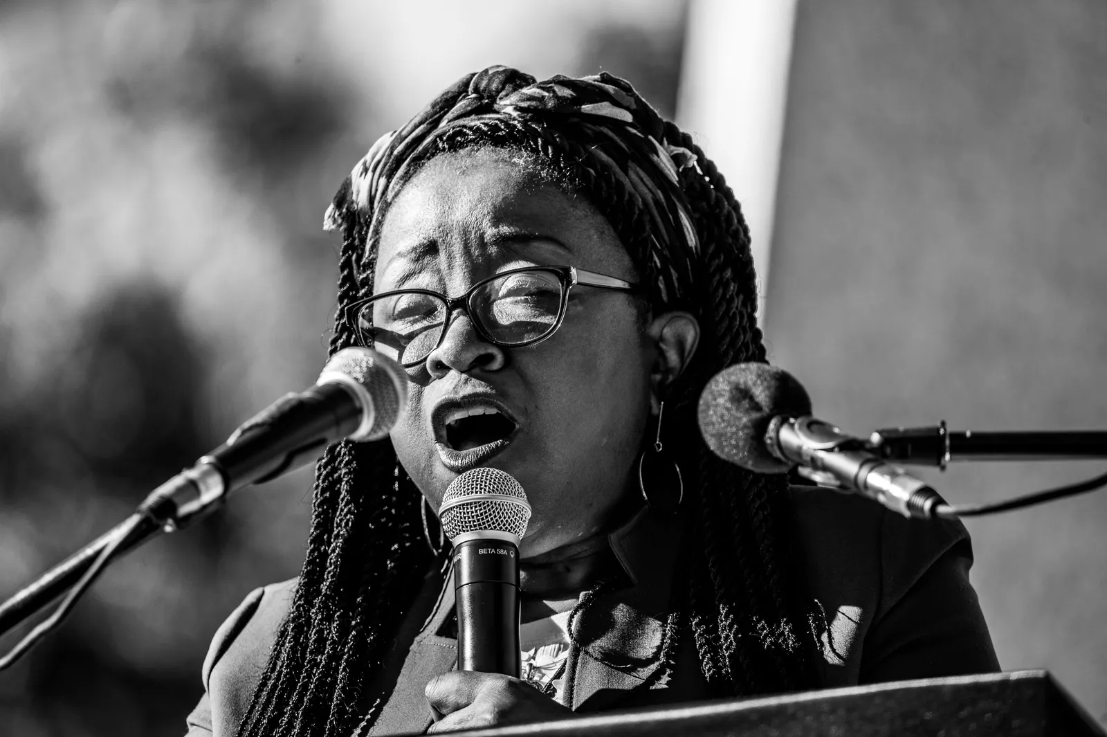 Black and white portrait of an woman singing into a microphone, exuding passion and emotion