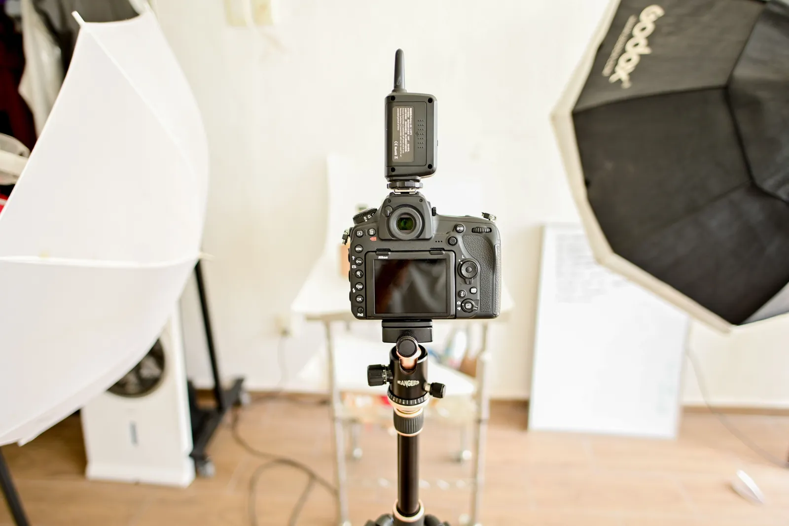 A DSLR camera setup in a professional indoor photography studio with lighting equipment