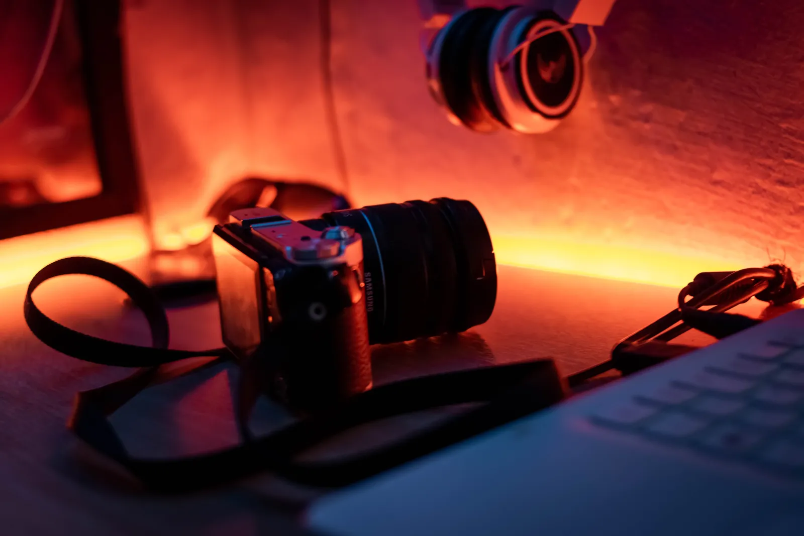 A close-up photo of a camera with a warm, moody lighting on a desk setup