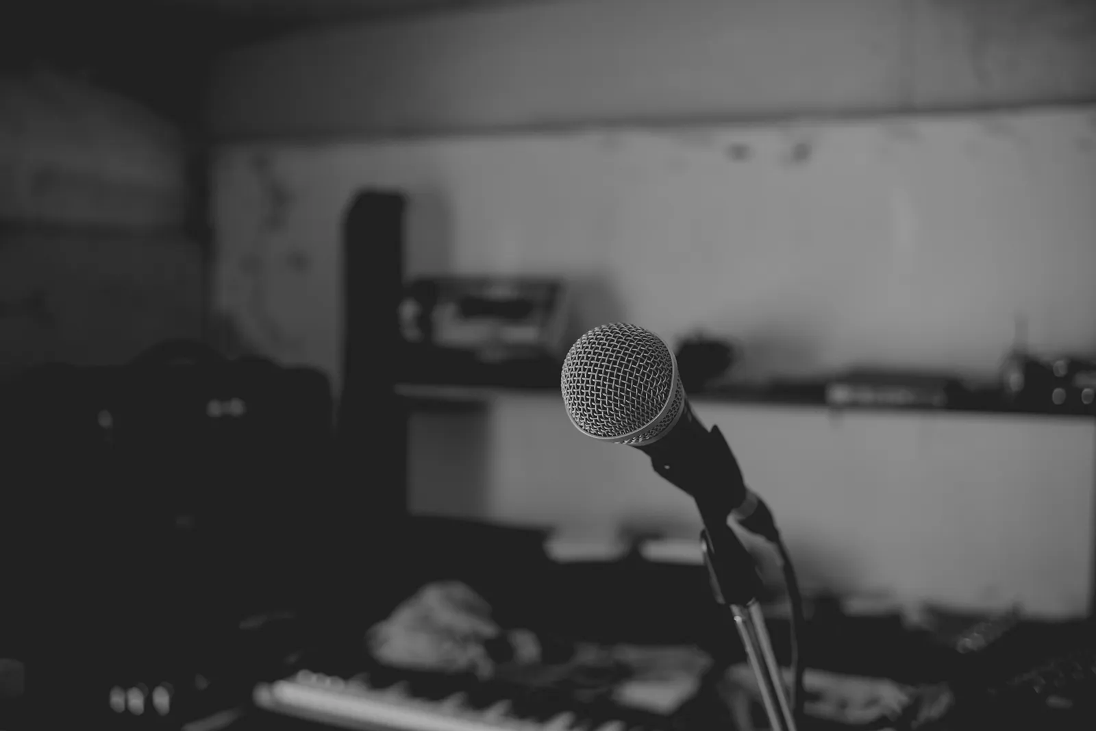 Artistic black and white shot of a music studio with a focus on a microphone. Perfect for music-themed projects