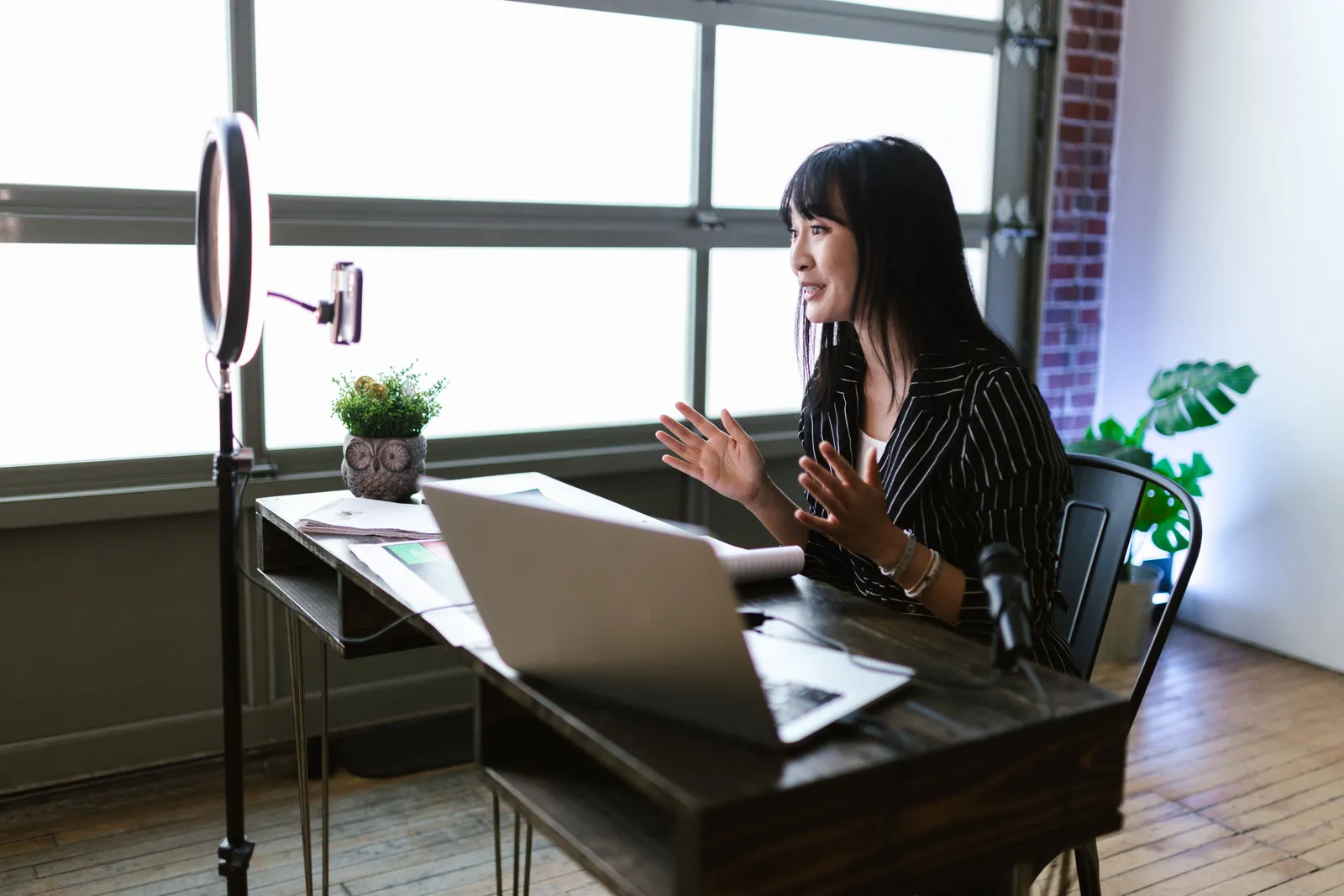 Woman engaging with audience through vlogging setup in stylish office space