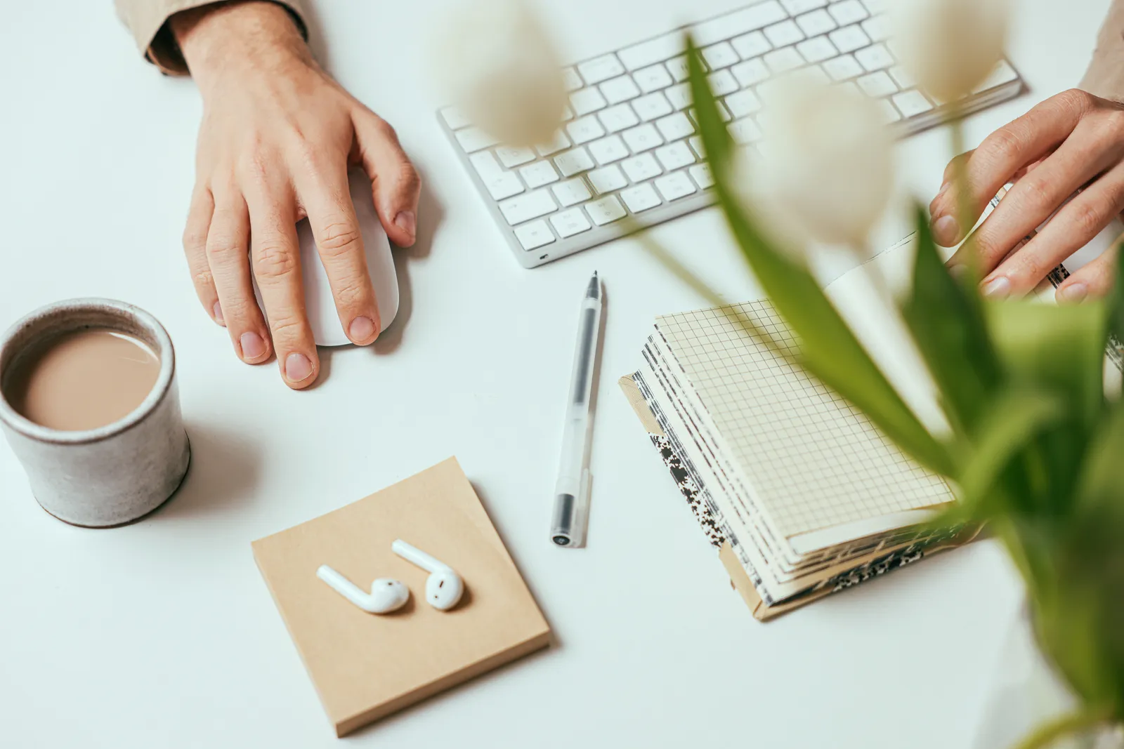 Stylish workspace with coffee, notebook, keyboard, and pen for productivity
