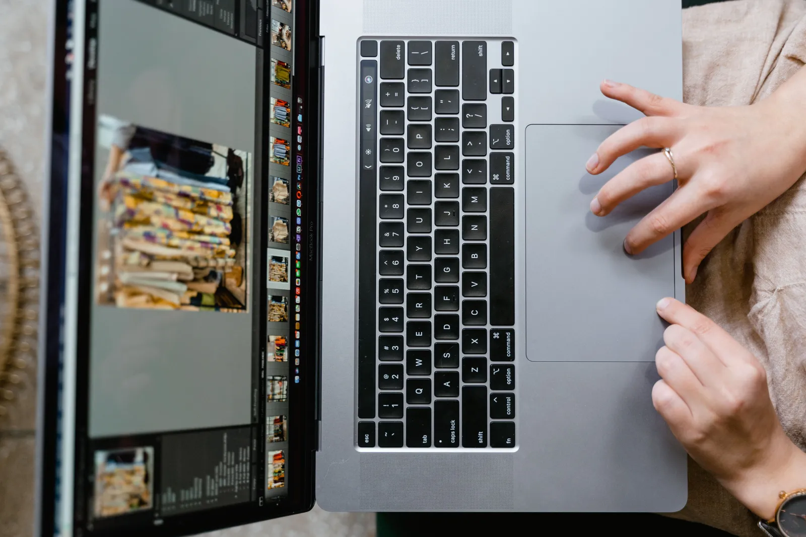 Close-up of hands using a laptop for photo editing, showcasing creativity in digital media