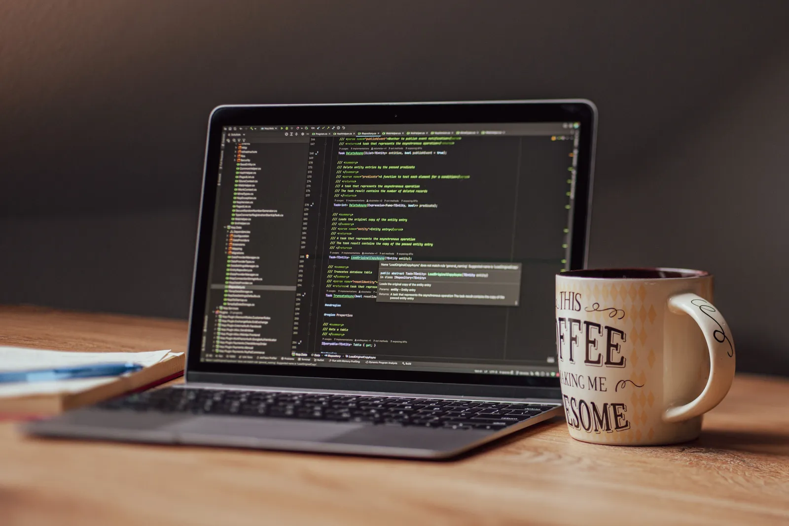 Laptop displaying code editor with coffee mug on desk, perfect for tech themes