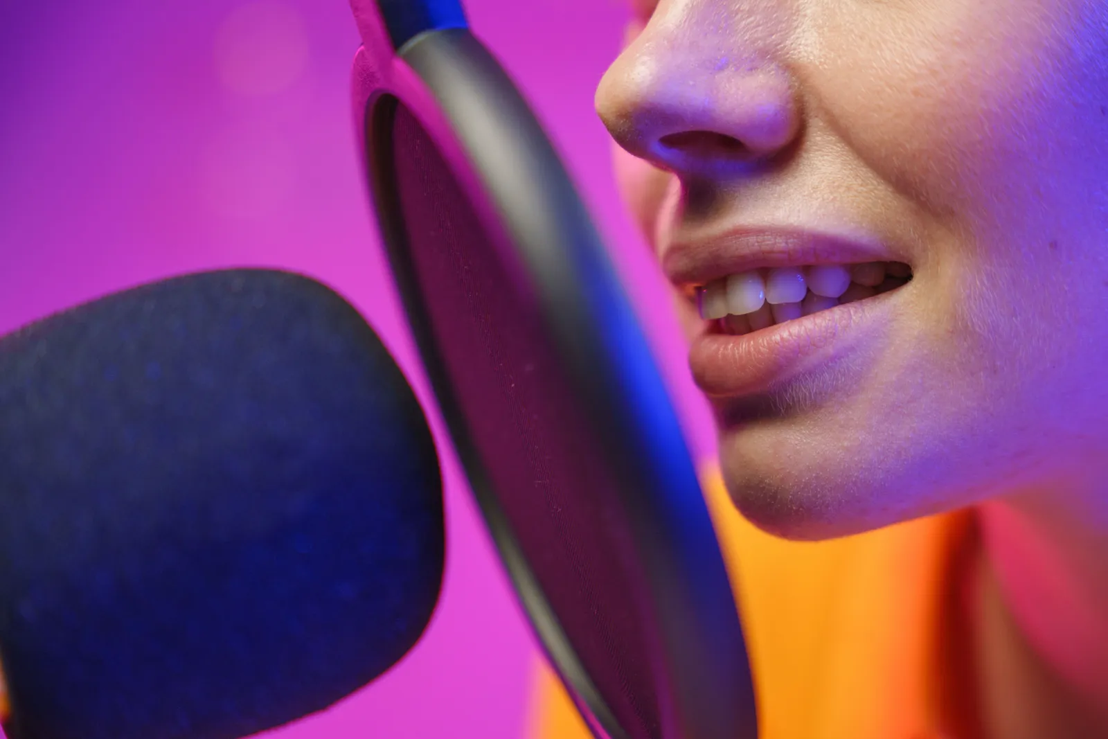 A woman podcasting with a microphone in a vibrant studio setting