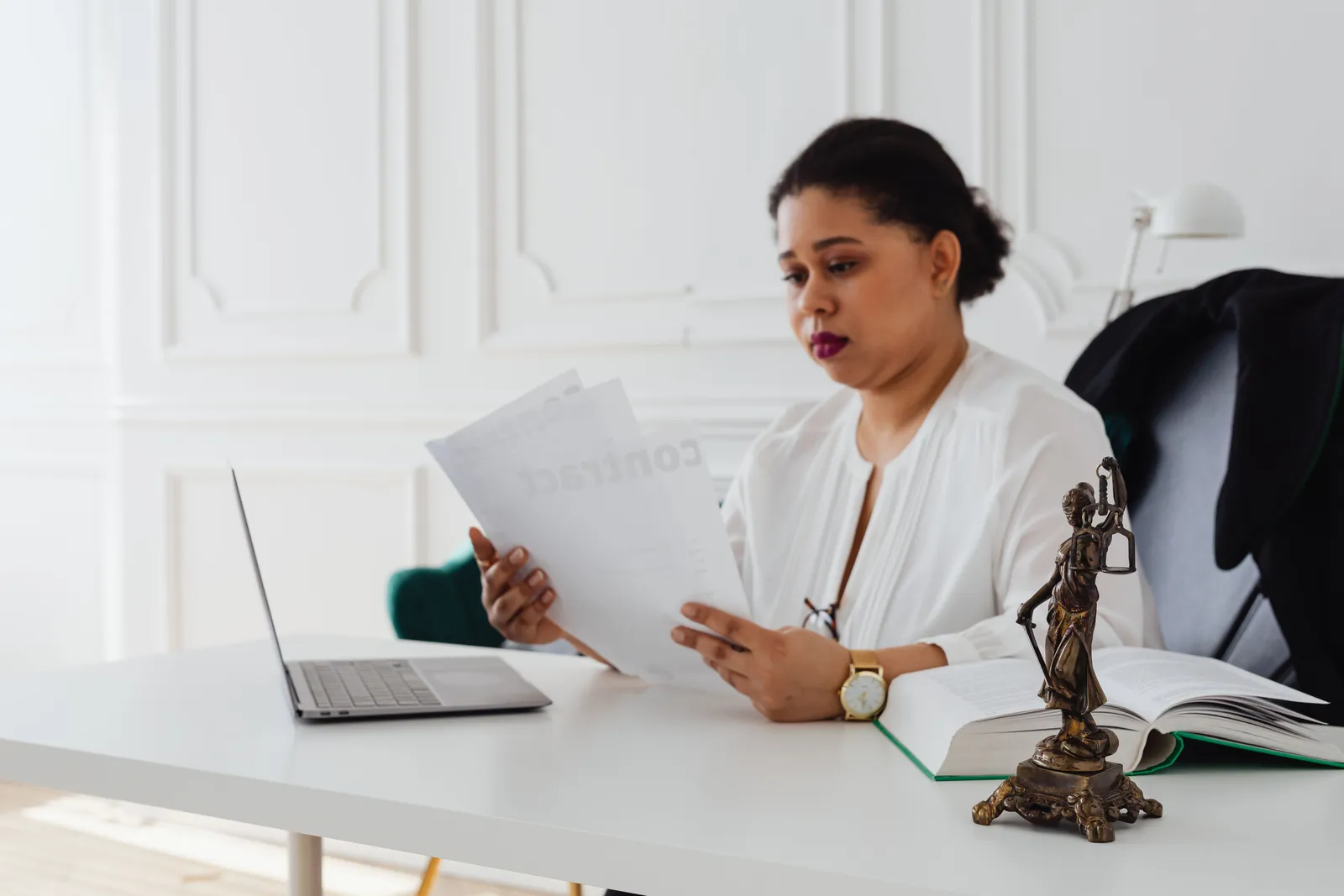 Woman lawyer reading legal papers at her desk in a modern office