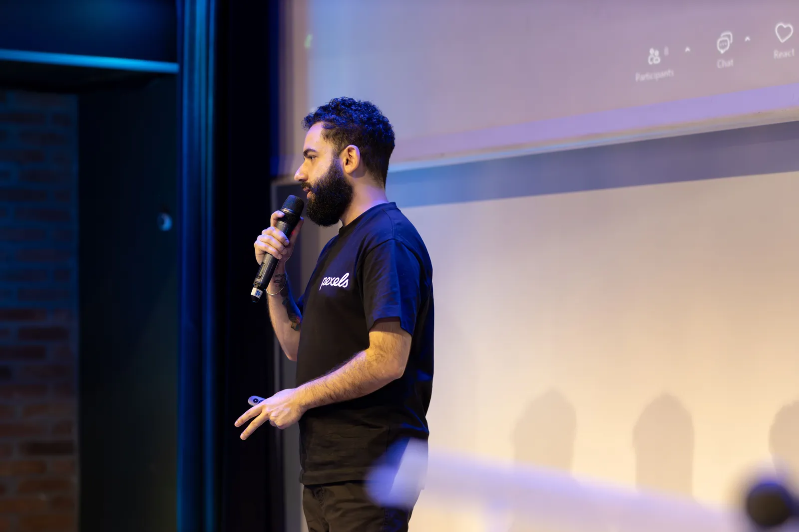 Man speaking into microphone during a presentation indoors
