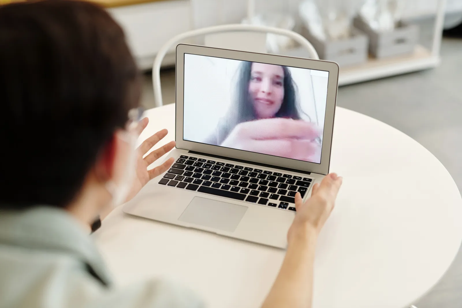 A person having a video call on a laptop, indoors, showcasing digital communication