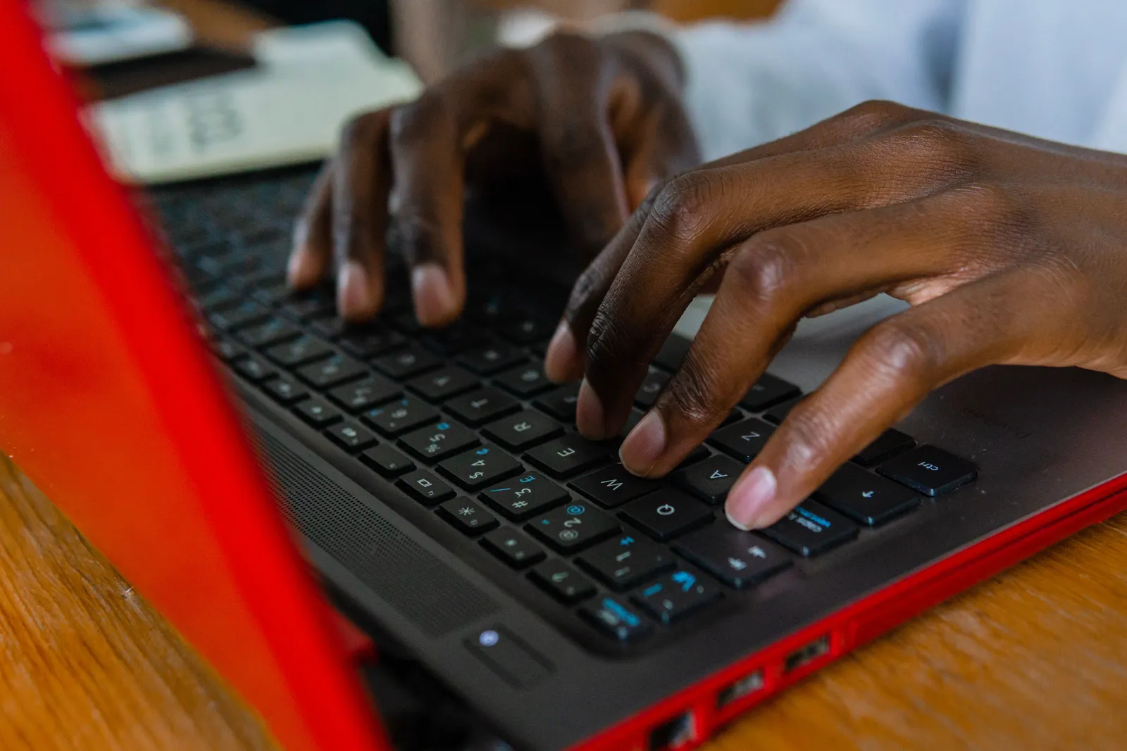 A detailed shot of hands typing on a laptop keyboard, highlighting tech engagement