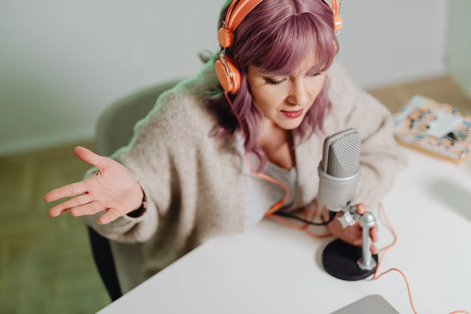 Woman using headphones and microphone to record a podcast indoors