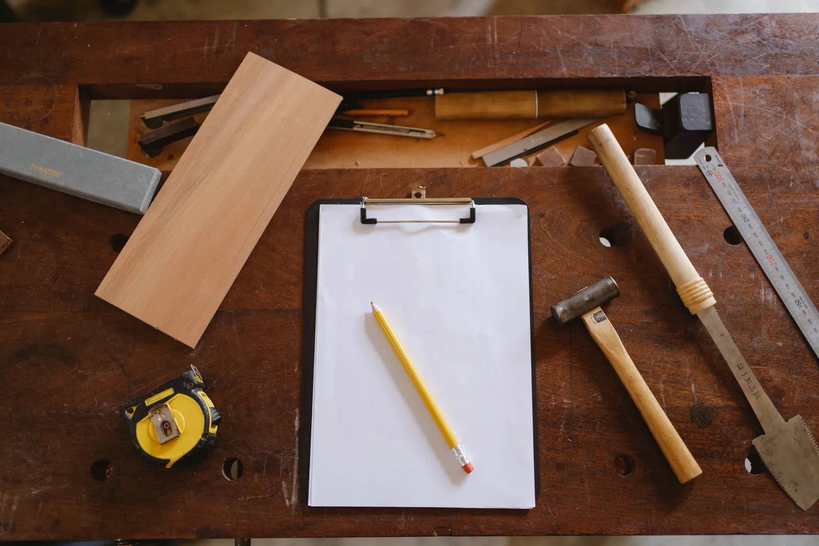 Flatlay of carpentry tools on a wooden workbench, showcasing craftsmanship essentials