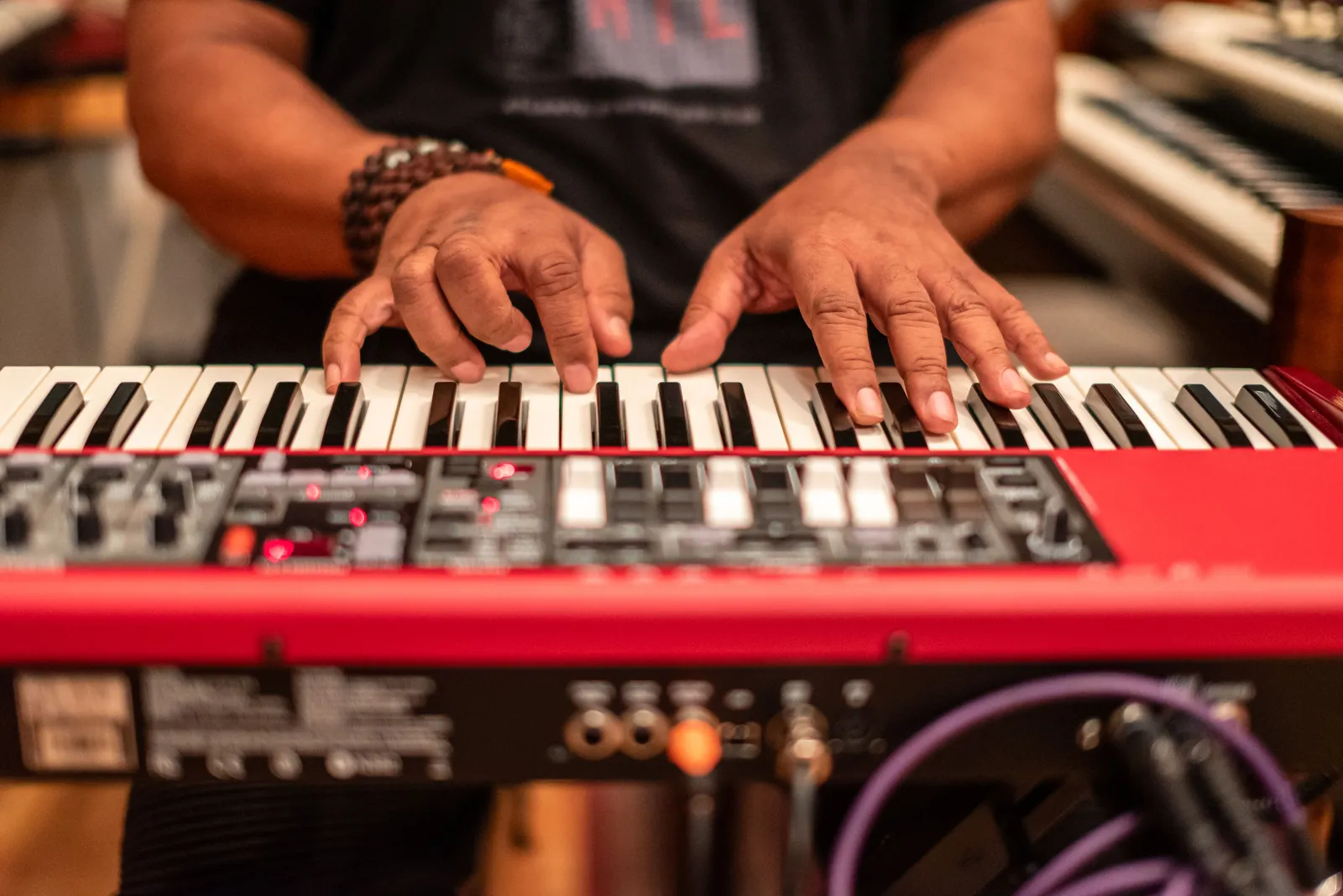 Close-up of musician's hands playing a keyboard in a recording studio