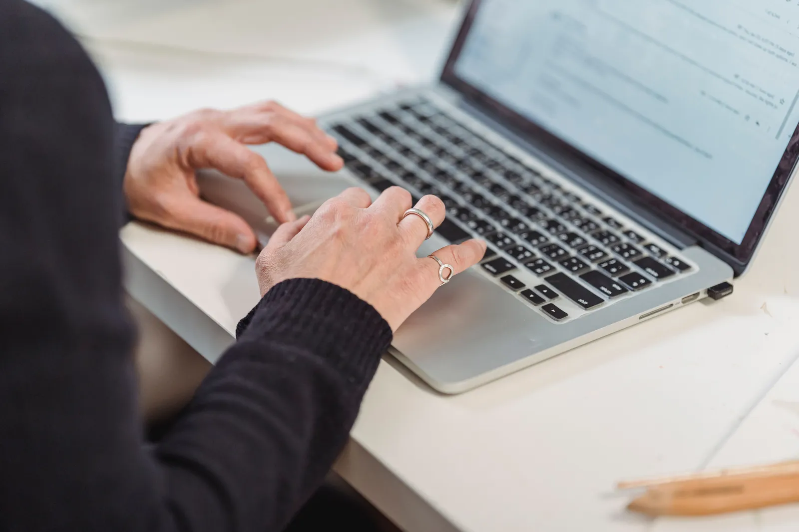 Close-up of hands typing on a laptop keyboard in a home office setting. Ideal for business and technology themes