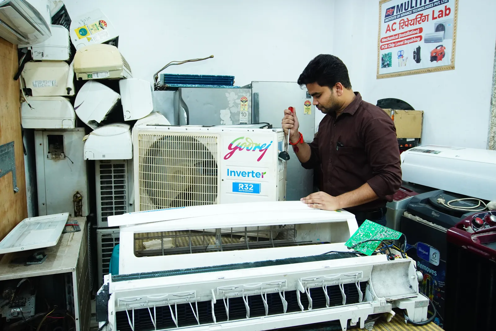 Technician repairing an air conditioner unit in New Delhi workshop