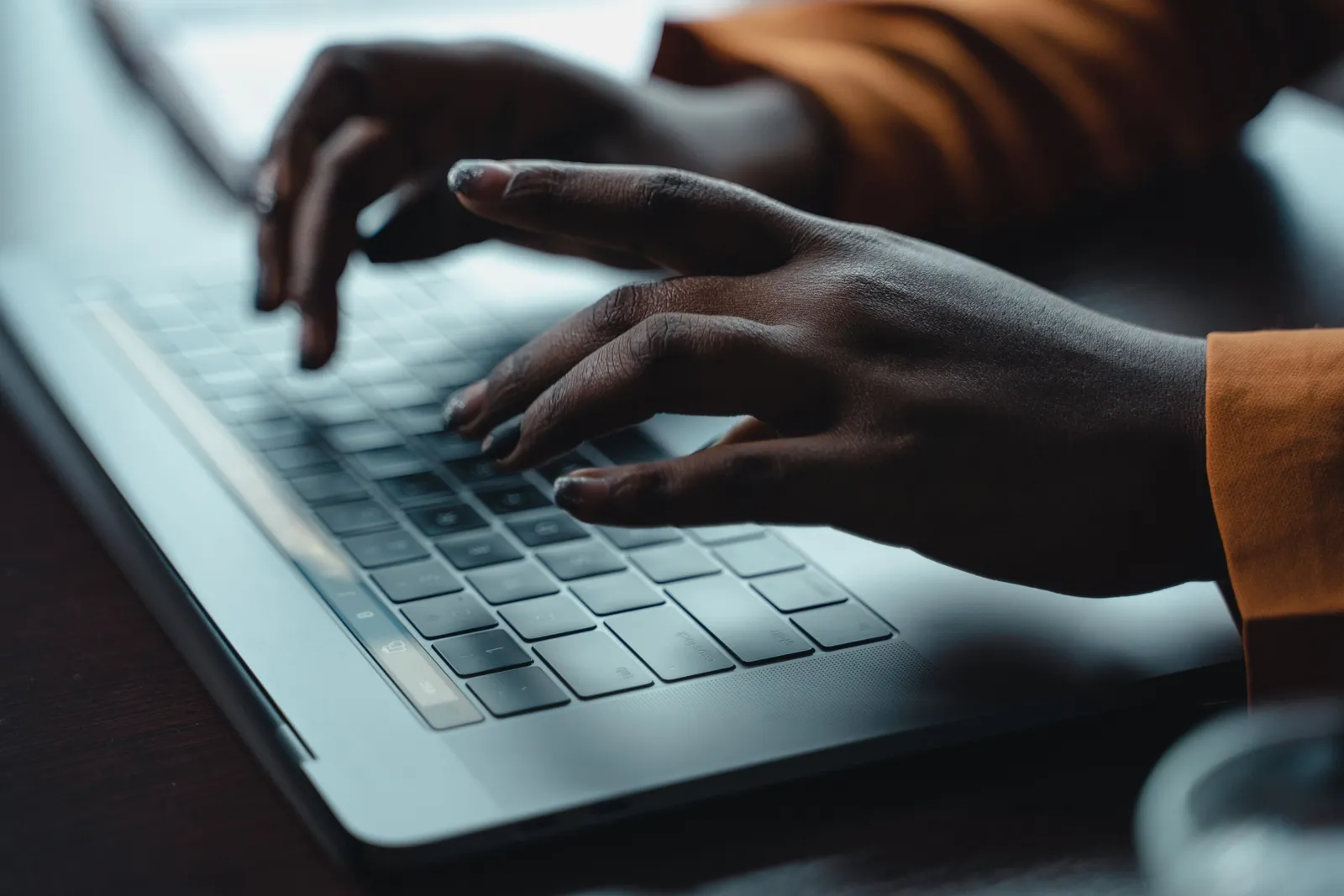 Close-up of hands typing on a laptop keyboard, capturing a moment of focused work