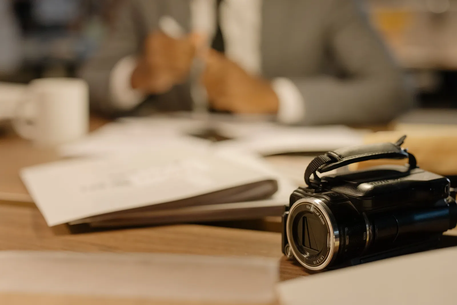 A camcorder on a desk in an office setting, capturing professional work activities