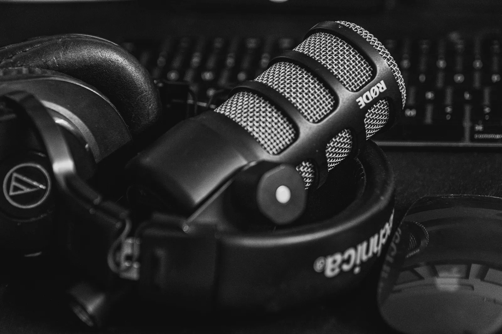 Close-up of a studio microphone and headphones in a black and white composition, perfect for audio and podcast themes