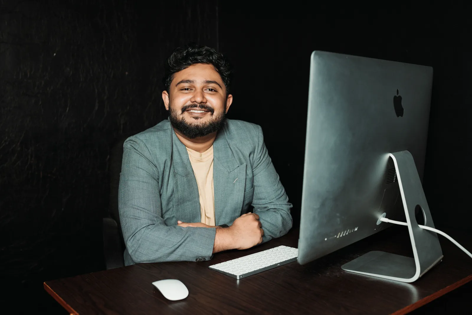 Confident businessman sitting at desk, working on computer in modern office