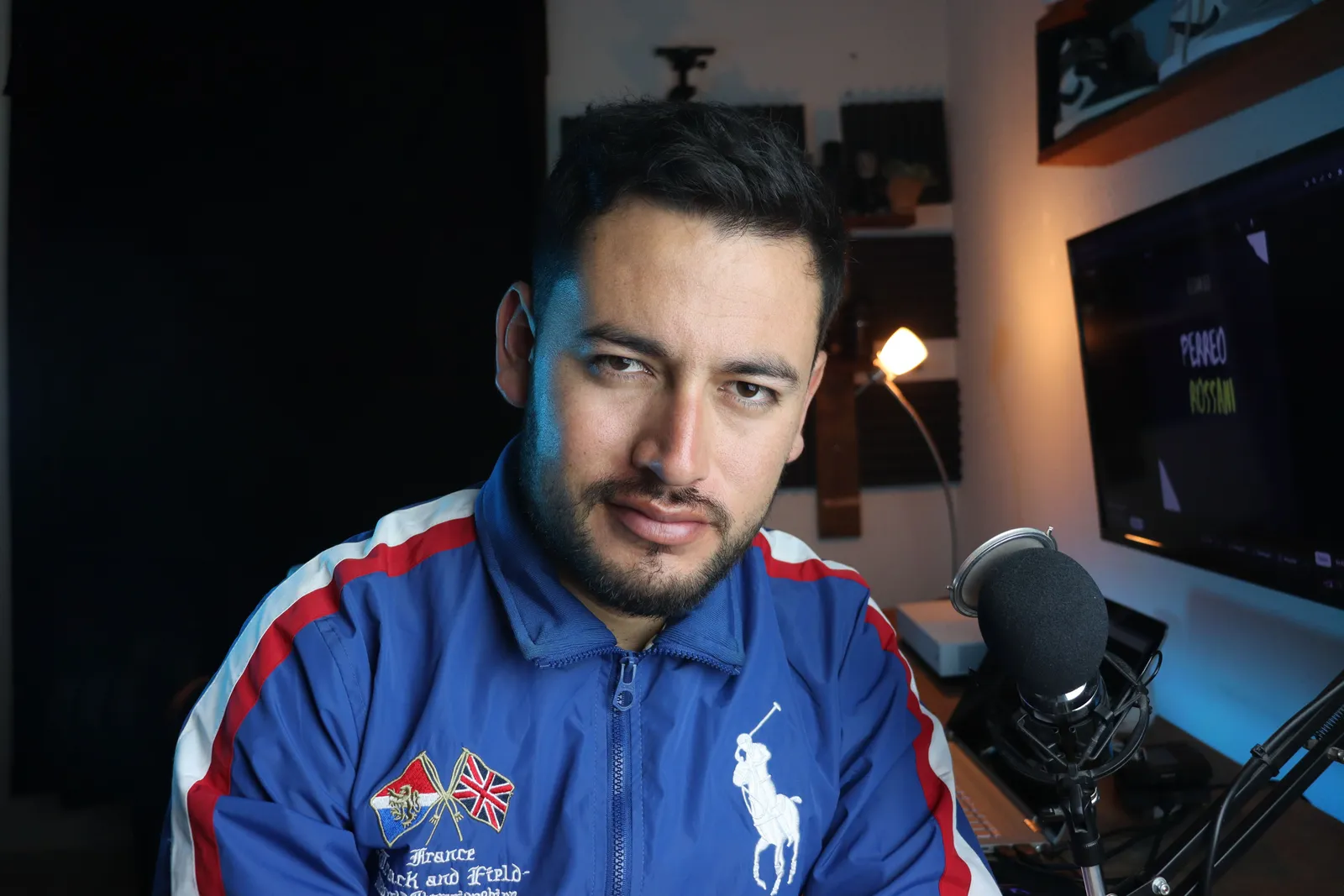 Close-up of a man in a home studio with microphone and computer setup