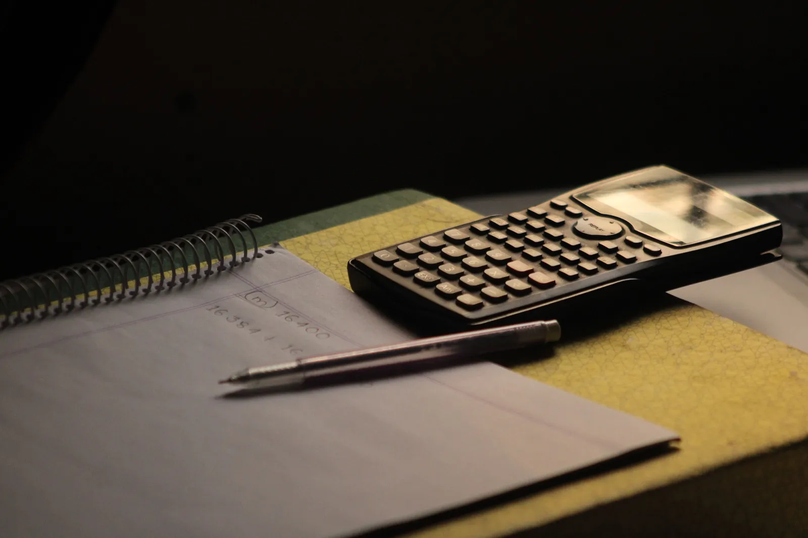 Close-up of a calculator and notebook on a study desk. Ideal for education themes