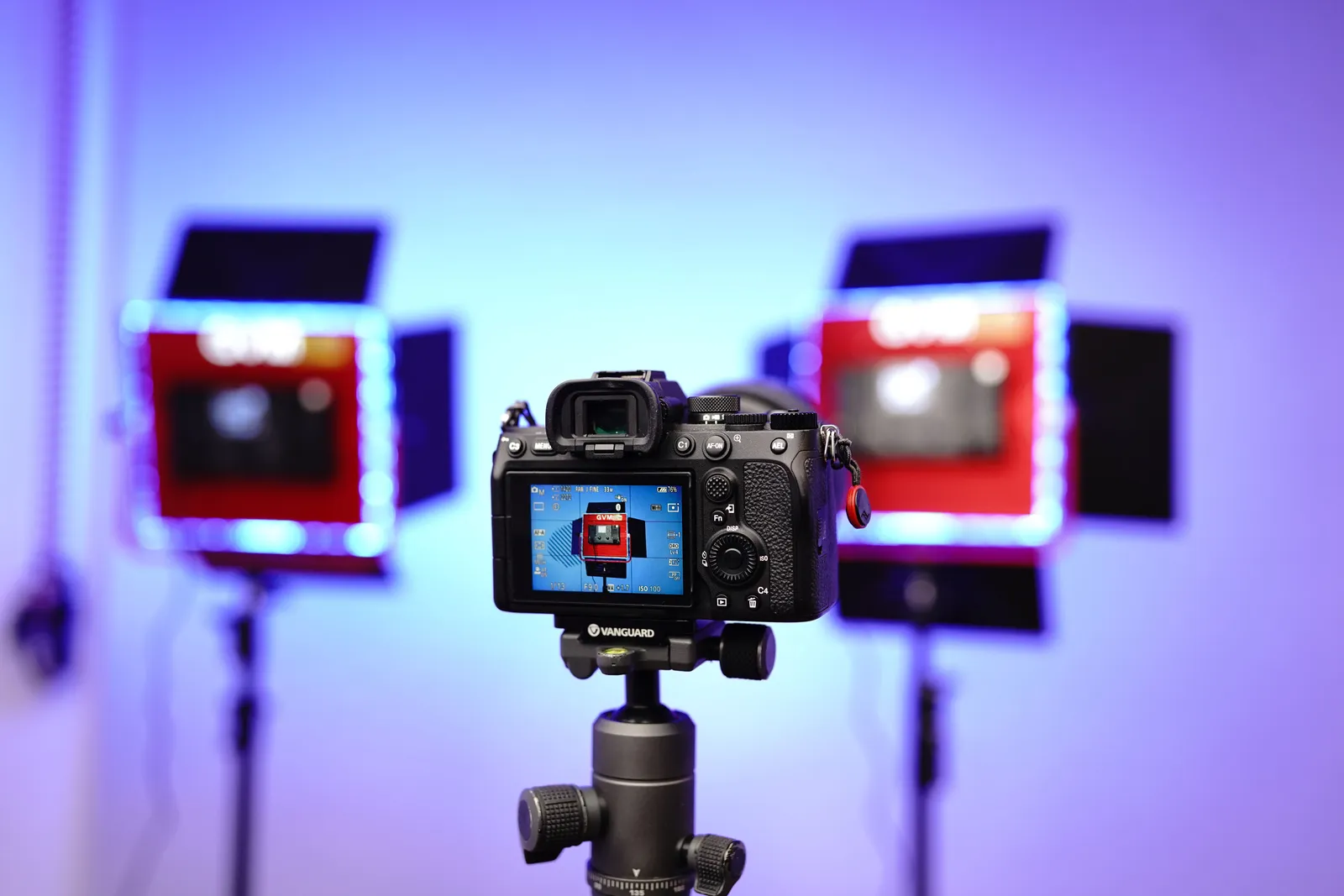 A DSLR camera on a tripod in a studio setting with illuminated lights and a professional setup