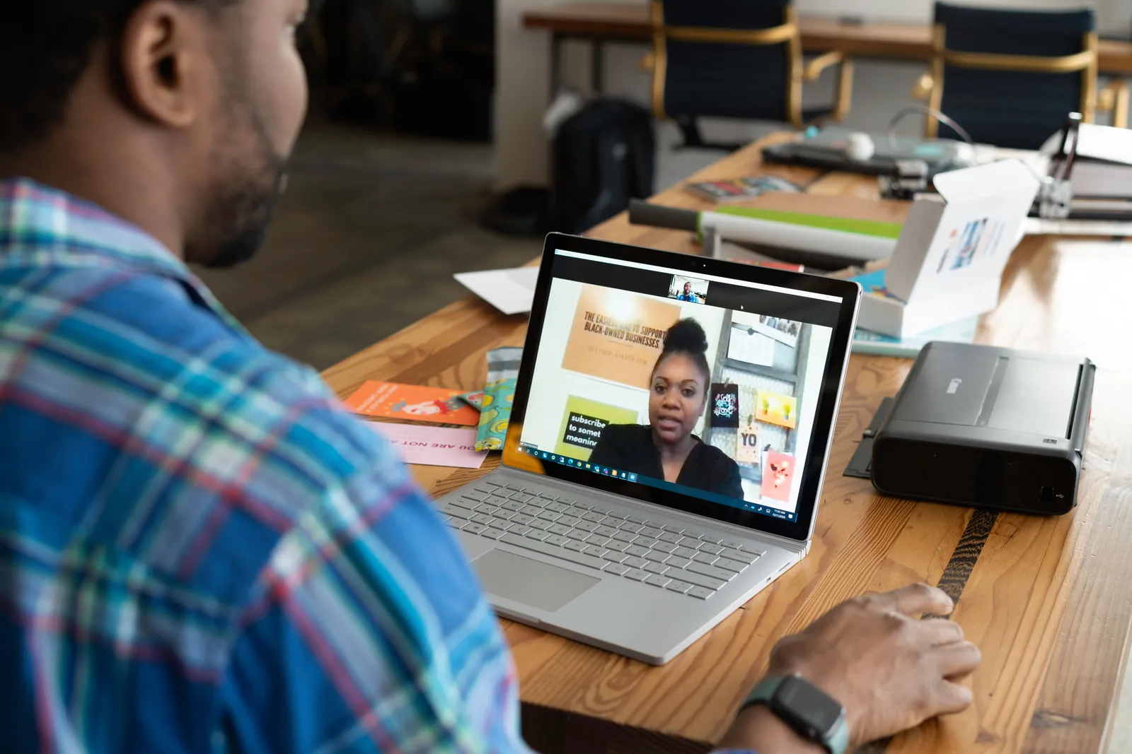 A businessman engaging in a virtual meeting using a laptop at an office desk